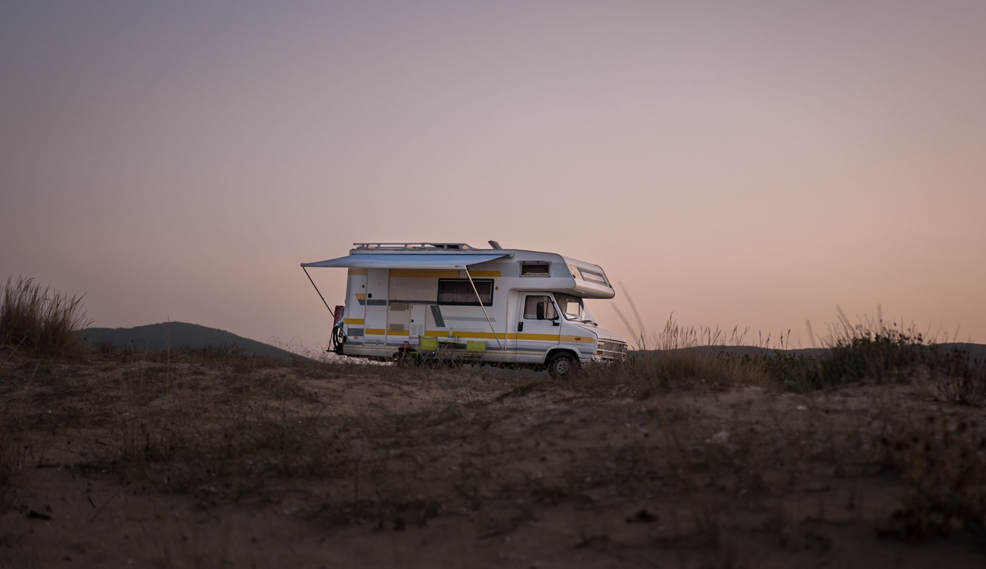 An RV parked in nature at sunset, ready for the road